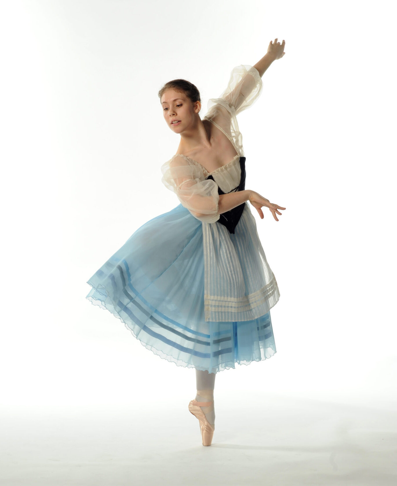 Natasha wearing a blue and cream "Giselle" dress with a black velvet bodice. She's en pointe in retire.