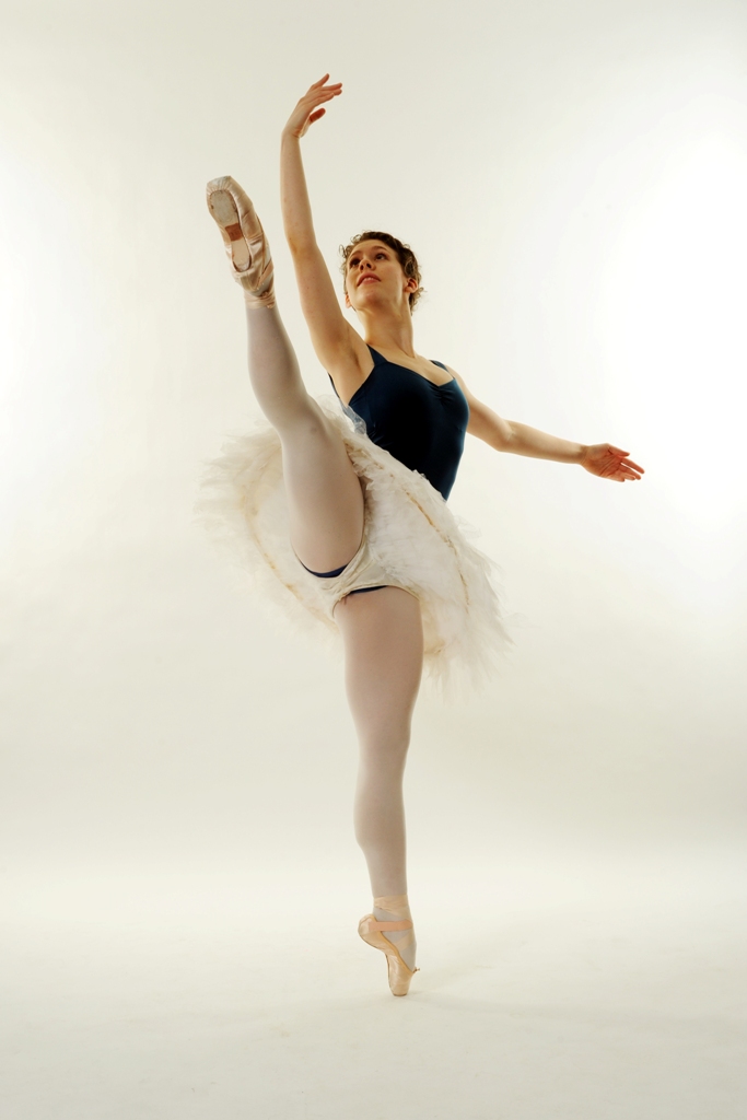 Natasha wearing a teal leotard, pink tights, and white practice tutu. She's en pointe in ecartez.